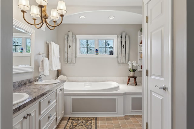bathroom featuring double vanity, an inviting chandelier, a sink, and a bath