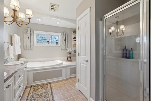 bathroom featuring an inviting chandelier, a sink, double vanity, a garden tub, and a stall shower
