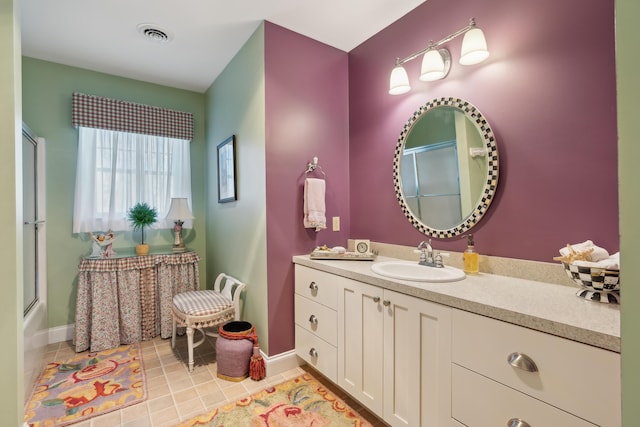 full bathroom featuring baseboards, visible vents, a shower with shower door, and vanity