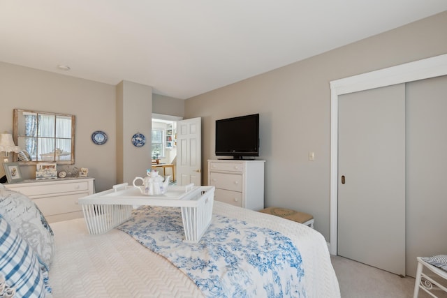 bedroom with light carpet and a closet