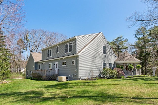 rear view of property with a lawn and a wooden deck