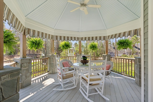 deck with a gazebo, outdoor dining area, and ceiling fan