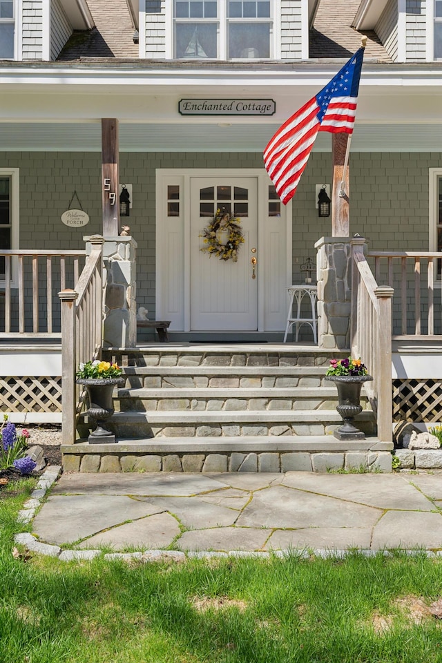property entrance with a porch and brick siding