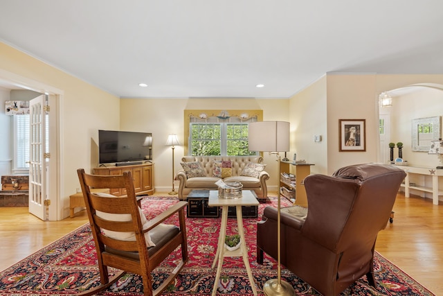 59 Beach Ave, Kennebunk, ME 04043 - living room featuring light wood-style floors, arched walkways, and ornamental molding