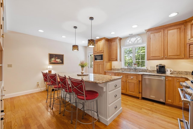 59 Beach Ave, Kennebunk, ME 04043 - kitchen featuring stainless steel appliances, a kitchen bar, a center island, light stone counters, and recessed lighting