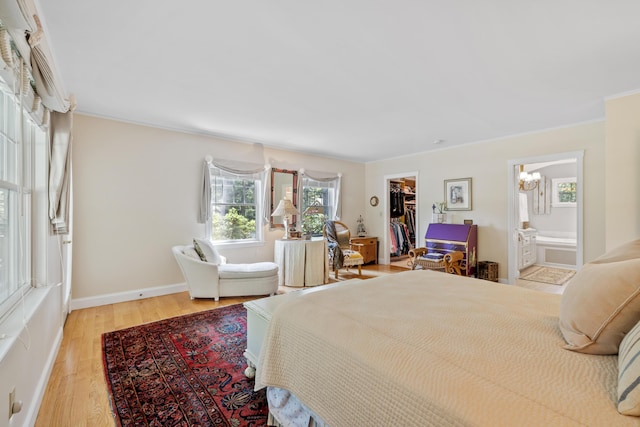 59 Beach Ave, Kennebunk, ME 04043 - bedroom with a chandelier, wood finished floors, crown molding, a walk in closet, and connected bathroom