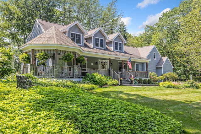 59 Beach Ave, Kennebunk, ME 04043 - view of front facade with covered porch, a front lawn, and a shingled roof