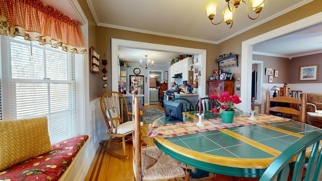 150 Enfield Rd, Lincoln, ME 04457 - dining space featuring ornamental molding, a chandelier, a wainscoted wall, washer / dryer, and wood finished floors