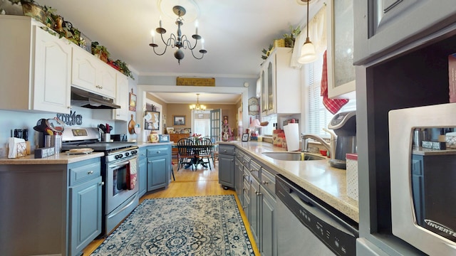 150 Enfield Rd, Lincoln, ME 04457 - kitchen featuring a notable chandelier, blue cabinetry, under cabinet range hood, stainless steel appliances, and a sink