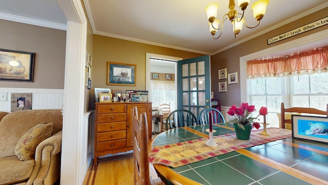 150 Enfield Rd, Lincoln, ME 04457 - dining room with wood finished floors, ornamental molding, a notable chandelier, and wainscoting