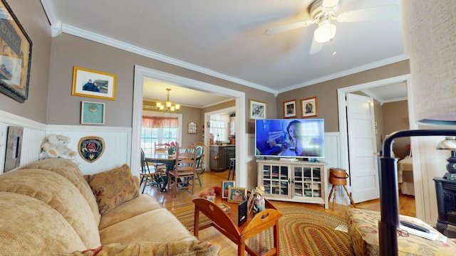 150 Enfield Rd, Lincoln, ME 04457 - living area featuring crown molding, ceiling fan with notable chandelier, wood finished floors, and wainscoting
