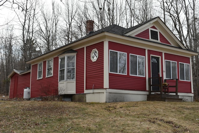 150 Enfield Rd, Lincoln, ME 04457 - view of home's exterior featuring entry steps, a lawn, and a chimney