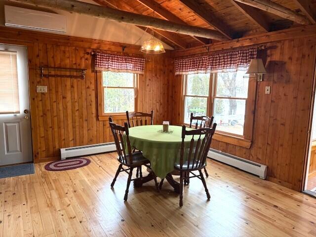 160 Pinkhams Cove Rd, Belgrade, ME 04917 - dining area with wood walls, baseboard heating, and light wood-type flooring