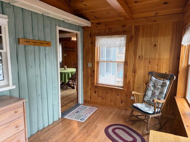 160 Pinkhams Cove Rd, Belgrade, ME 04917 - sitting room featuring wooden walls, wood ceiling, beam ceiling, and wood finished floors