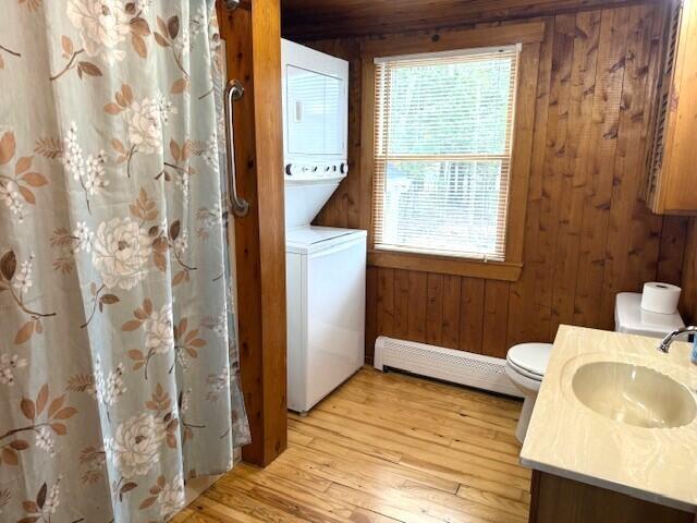 160 Pinkhams Cove Rd, Belgrade, ME 04917 - full bath with plenty of natural light, wood walls, stacked washing maching and dryer, and a baseboard heating unit