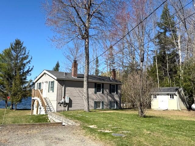 160 Pinkhams Cove Rd, Belgrade, ME 04917 - view of side of property featuring an outdoor structure, a chimney, a yard, and a shed