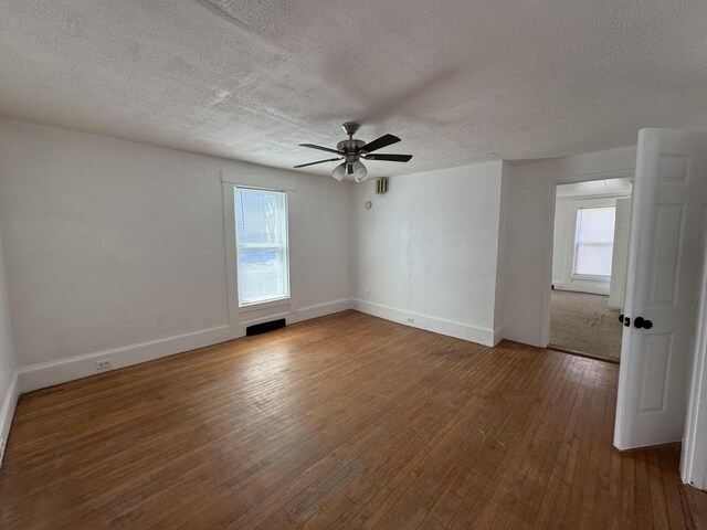 159 Elm St, Bangor, ME 04401 - empty room featuring a textured ceiling, hardwood / wood-style floors, ceiling fan, healthy amount of natural light, and baseboards