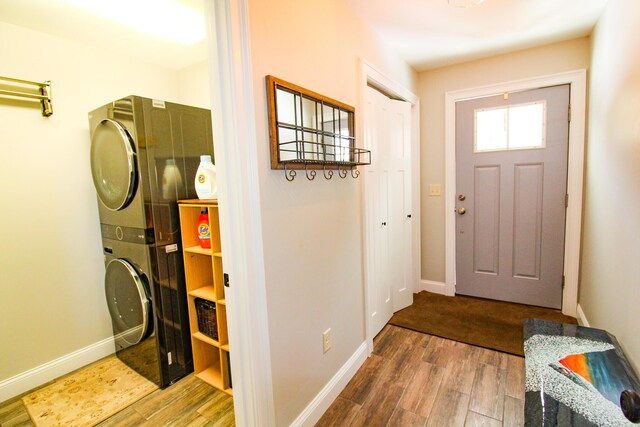 28 First St, Bethel, ME 04217 - entrance foyer with stacked washing machine and dryer, wood finished floors, and baseboards