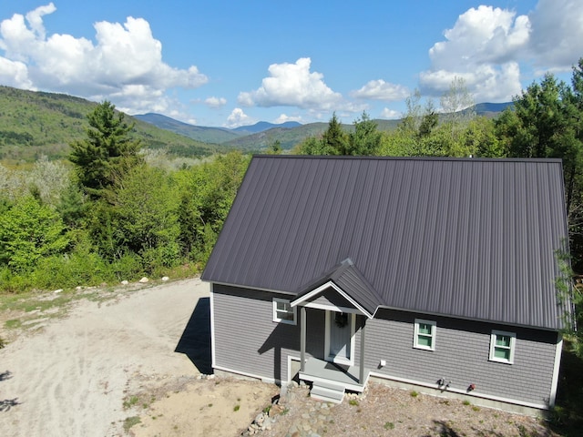 28 First St, Bethel, ME 04217 - view of front facade with metal roof and a mountain view