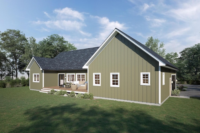 back of property with a lawn, a wooden deck, and board and batten siding