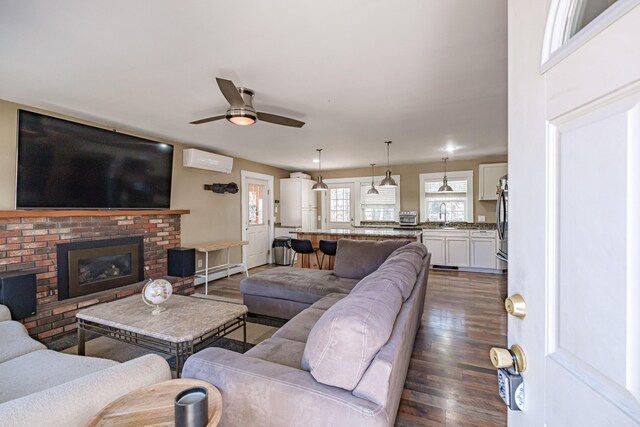 living area with ceiling fan, baseboard heating, a fireplace, a wall unit AC, and dark wood-type flooring