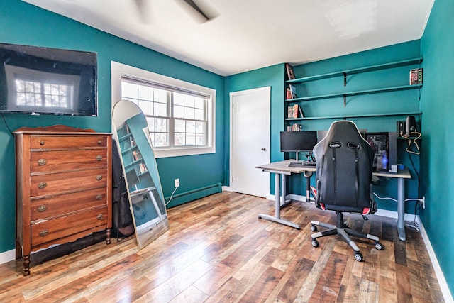 office featuring baseboards, baseboard heating, and wood finished floors