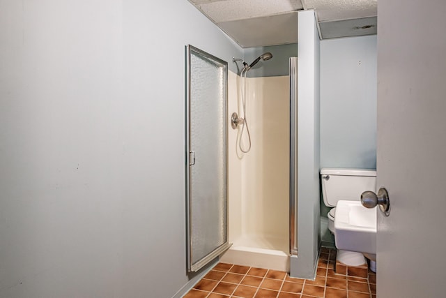 full bathroom with toilet, tile patterned floors, and a shower stall