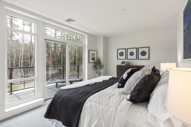 bedroom with access to exterior, carpet flooring, and visible vents