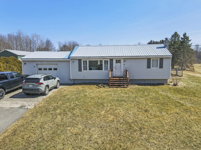 834 Main St, Bradley, ME 04411 - ranch-style home with metal roof, a front yard, a garage, and aphalt driveway