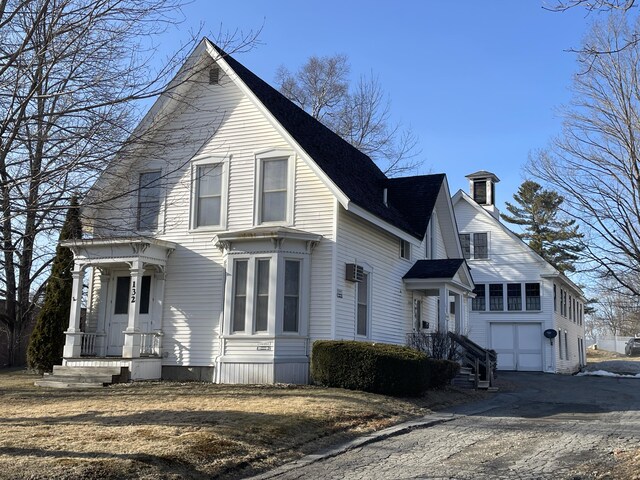 view of front of house featuring a garage, aphalt driveway, and a chimney