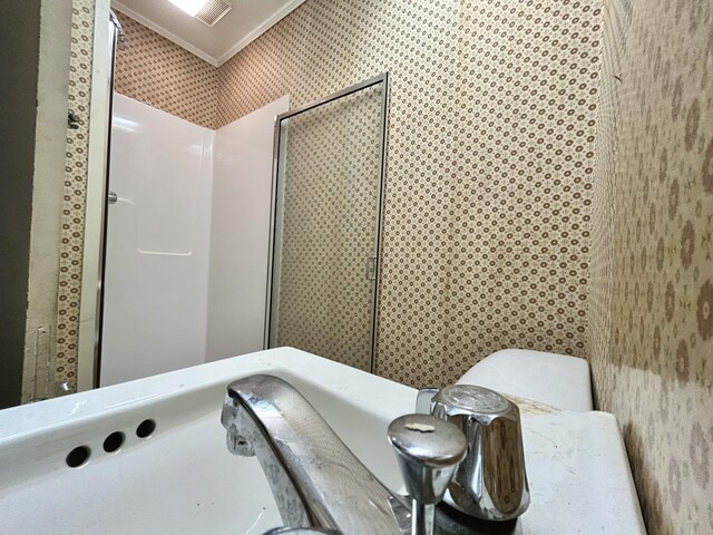 bathroom with ornamental molding, walk in shower, and wallpapered walls