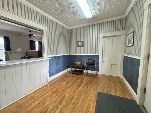 sitting room with an ornate ceiling, wallpapered walls, and ornamental molding