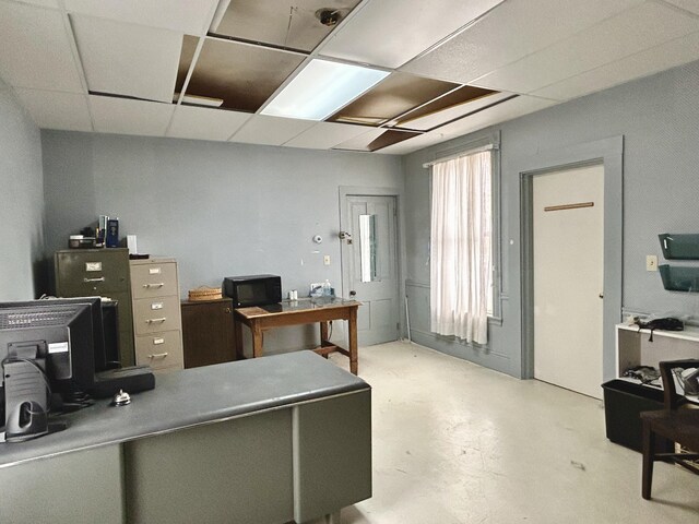 office featuring concrete floors and a drop ceiling