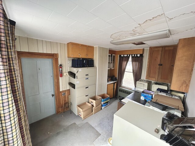 office space with radiator heating unit and wooden walls
