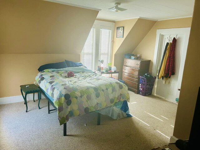 bedroom with crown molding, carpet flooring, baseboards, and lofted ceiling