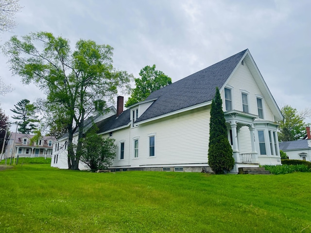 132 E Main St, Dover-Foxcroft, ME 04426 - view of home's exterior featuring a chimney, a yard, and roof with shingles