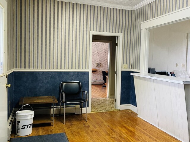 132 E Main St, Dover-Foxcroft, ME 04426 - sitting room featuring wallpapered walls, wood finished floors, a wainscoted wall, ornamental molding, and a baseboard heating unit