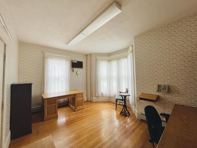 132 E Main St, Dover-Foxcroft, ME 04426 - home office with light wood-type flooring, a baseboard radiator, wallpapered walls, and an AC wall unit