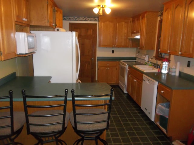 8 Varney Loop, Crawford, ME 04694 - kitchen with under cabinet range hood, white appliances, a sink, a peninsula, and dark countertops