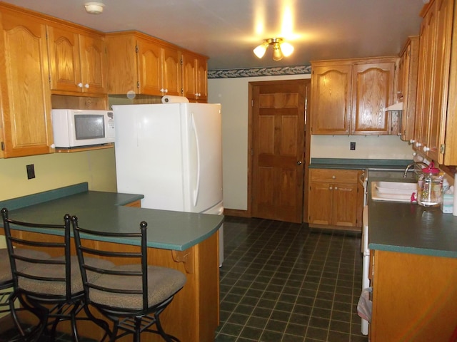8 Varney Loop, Crawford, ME 04694 - kitchen featuring a breakfast bar area, under cabinet range hood, a sink, white microwave, and a peninsula