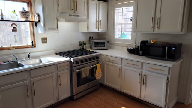 5 Johnson St, Eastport, ME 04631 - kitchen with light countertops, a toaster, under cabinet range hood, black microwave, and high end stainless steel range
