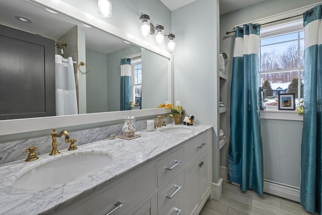 51 Bridge St, Belfast, ME 04915 - bathroom with baseboards, double vanity, a baseboard radiator, and a sink