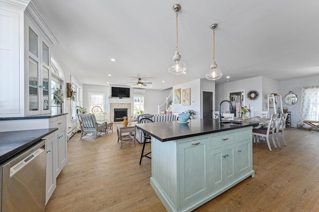 51 Bridge St, Belfast, ME 04915 - kitchen with a fireplace with raised hearth, dishwasher, a sink, dark countertops, and a ceiling fan