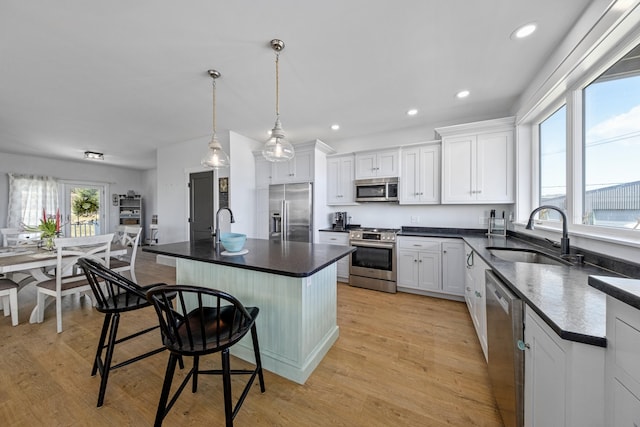 51 Bridge St, Belfast, ME 04915 - kitchen with white cabinetry, a breakfast bar, appliances with stainless steel finishes, dark countertops, and a sink
