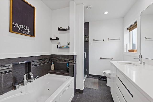 full bath with toilet, vanity, a jetted tub, baseboards, and recessed lighting