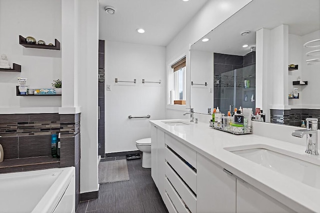bathroom with backsplash, baseboards, a stall shower, and a sink