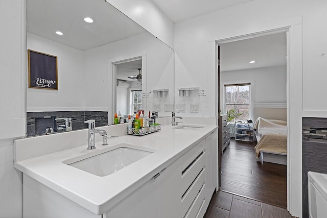 bathroom with recessed lighting, double vanity, ceiling fan, and a sink