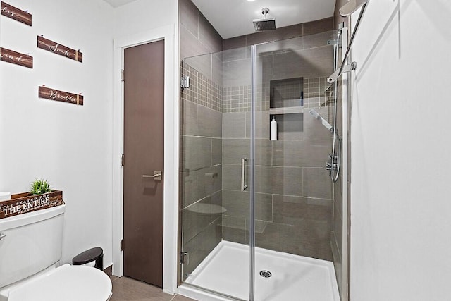 full bathroom with toilet and a stall shower