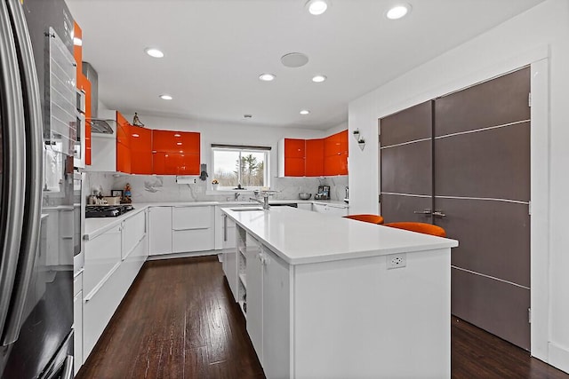 kitchen featuring decorative backsplash, freestanding refrigerator, light countertops, dark wood-style floors, and recessed lighting