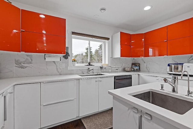kitchen featuring backsplash, a sink, dishwashing machine, and recessed lighting